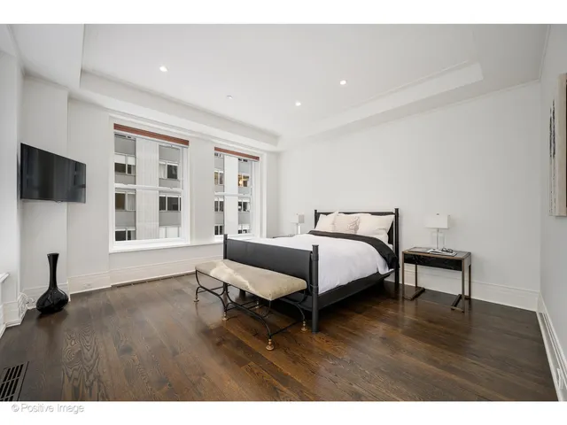 a bed room with a bed tv and a window