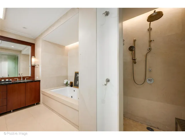 a en suite bathroom with a tub shower and mirror