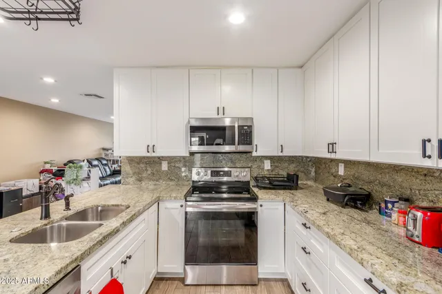 a kitchen with stainless steel appliances granite countertop a sink stove and refrigerator