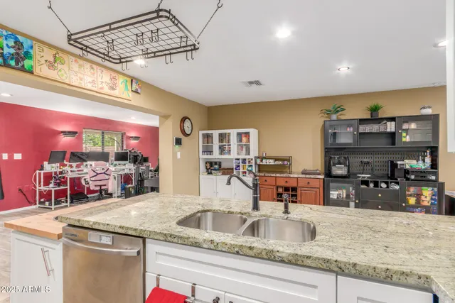 a kitchen with stainless steel appliances granite countertop a sink window and cabinets