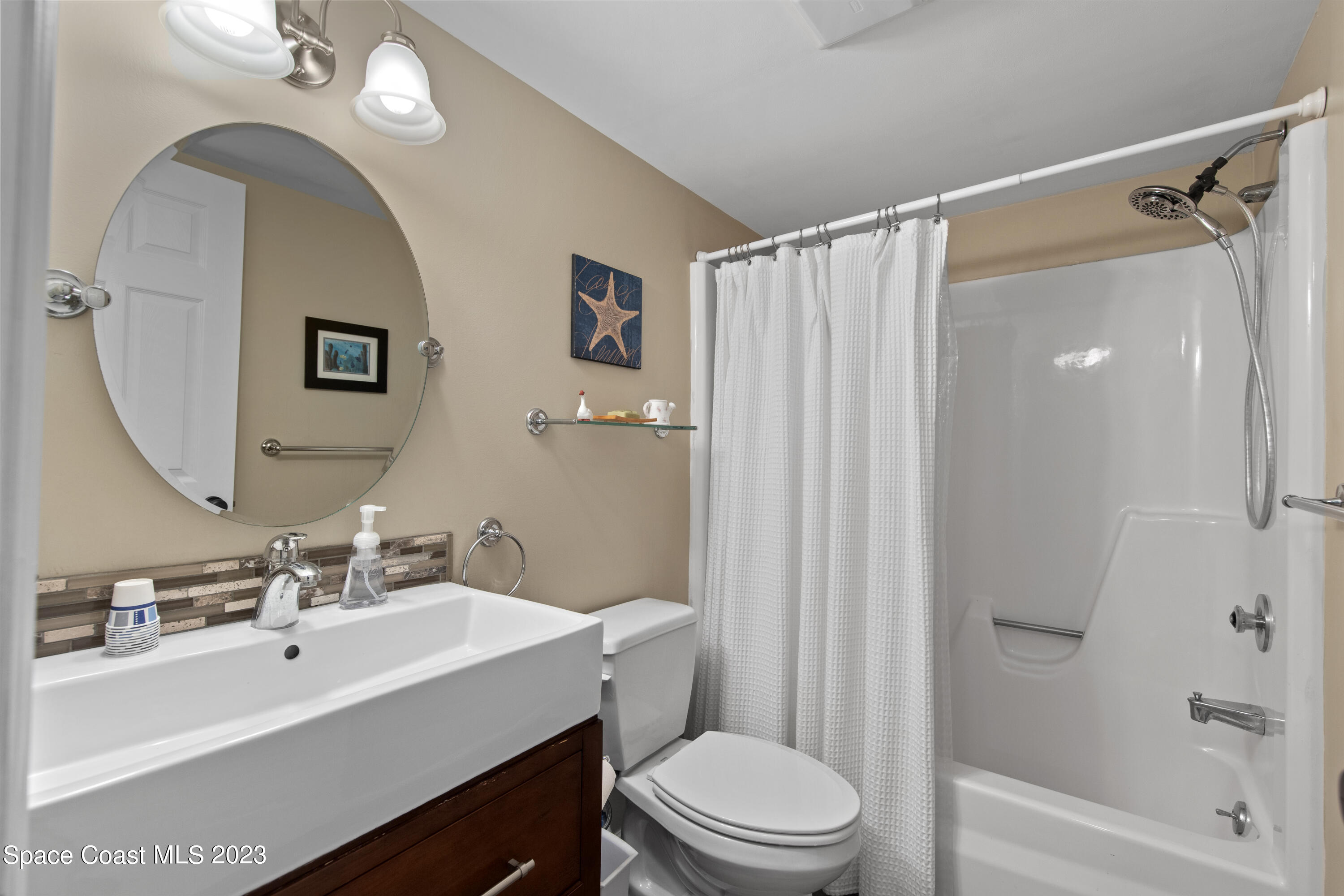 4150 Florida A1A, Unit 104 Vero Beach, FL 32963 - Photo 17 of 30 a bathroom with a sink a toilet a mirror and shower