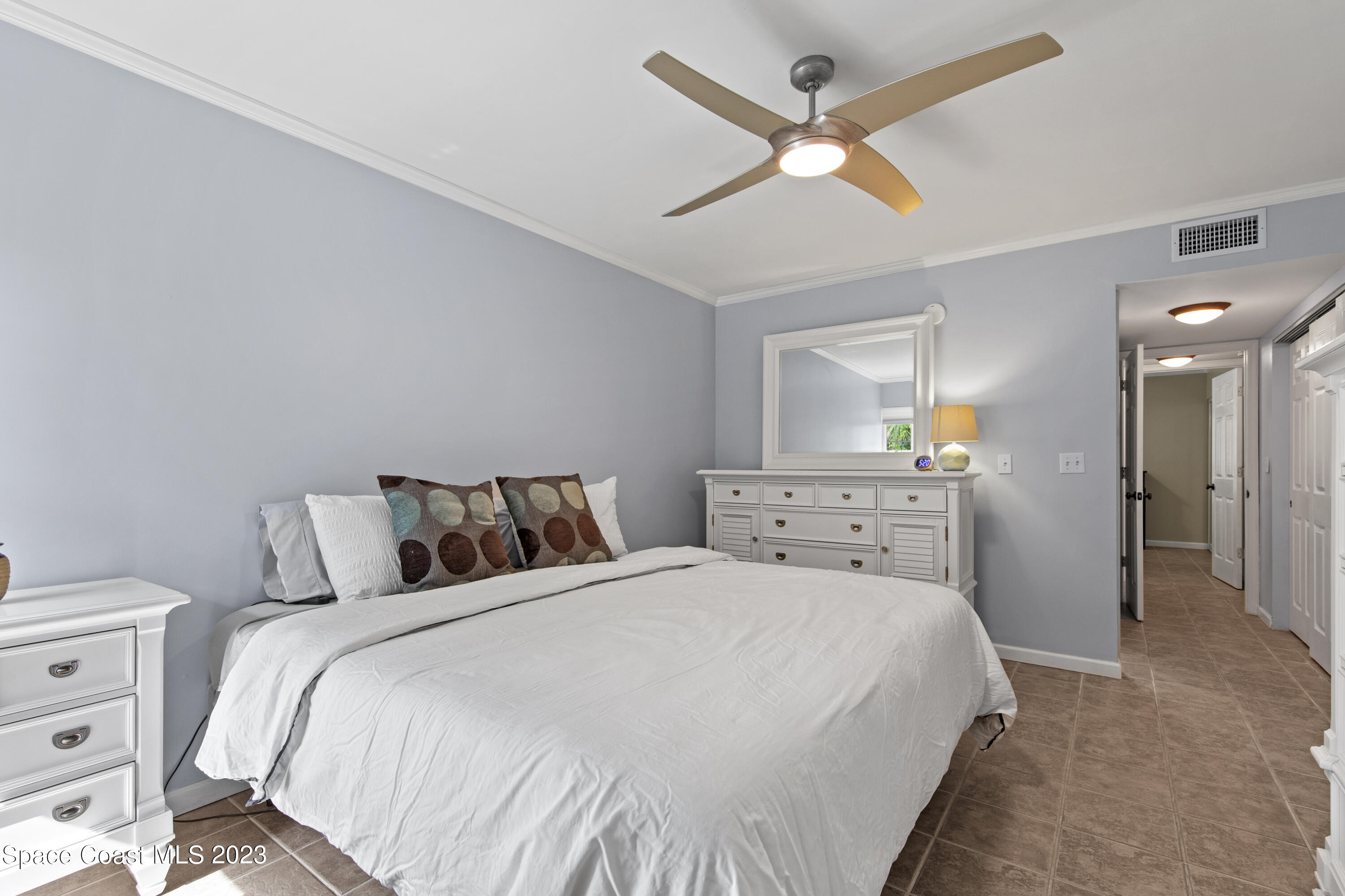 4150 Florida A1A, Unit 104 Vero Beach, FL 32963 - Photo 20 of 30 a bedroom with a bed and a ceiling fan