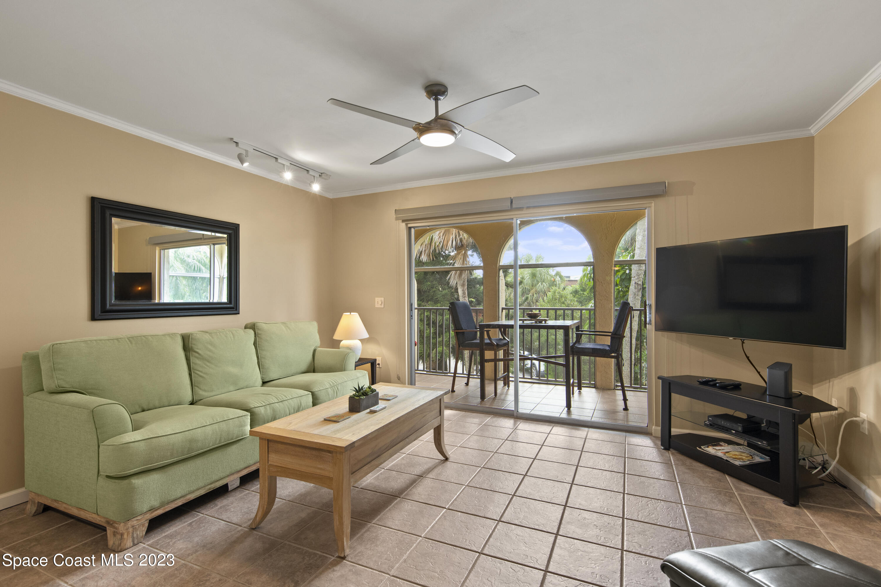 4150 Florida A1A, Unit 104 Vero Beach, FL 32963 - Photo 3 of 30 a living room with furniture a flat screen tv and a floor to ceiling window