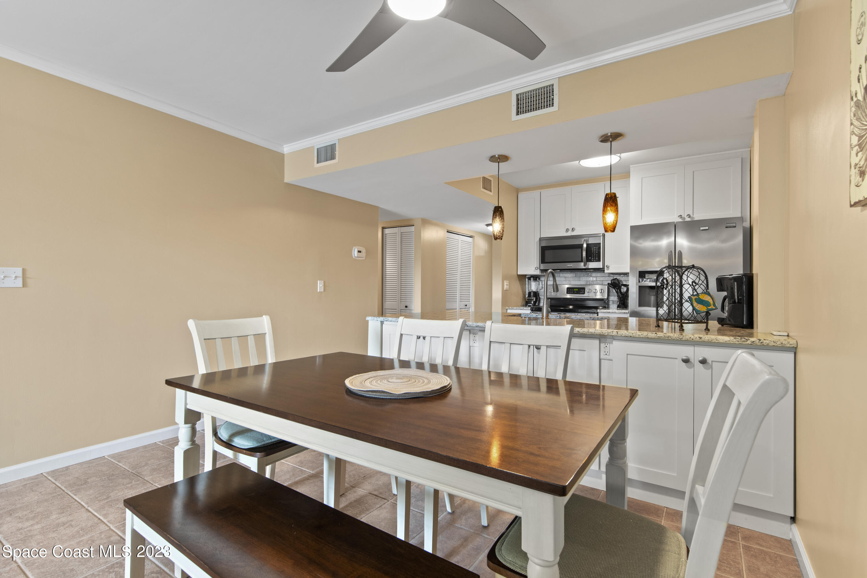 4150 Florida A1A, Unit 104 Vero Beach, FL 32963 - Photo 8 of 30 a kitchen with stainless steel appliances a dining table and chairs