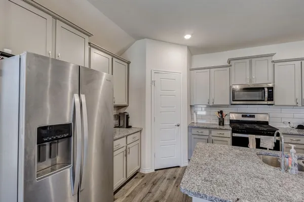a kitchen with stainless steel appliances a refrigerator stove and microwave