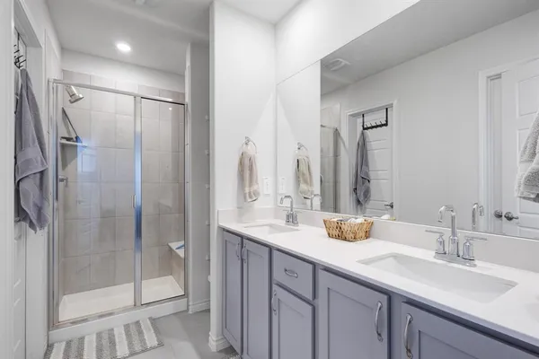 a bathroom with a shower sink and mirror