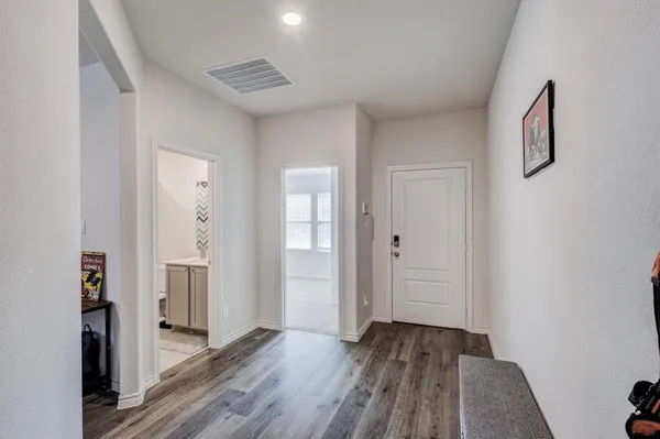 a view of a hallway with wooden floor and entryway