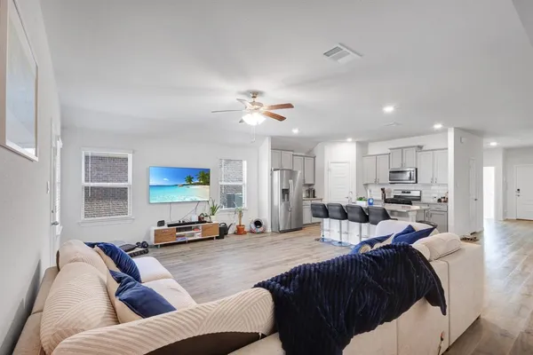 a living room with furniture kitchen view and a window