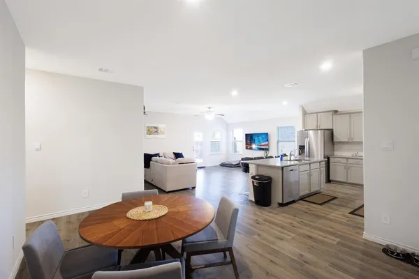 a kitchen with a dining table chairs and kitchen view