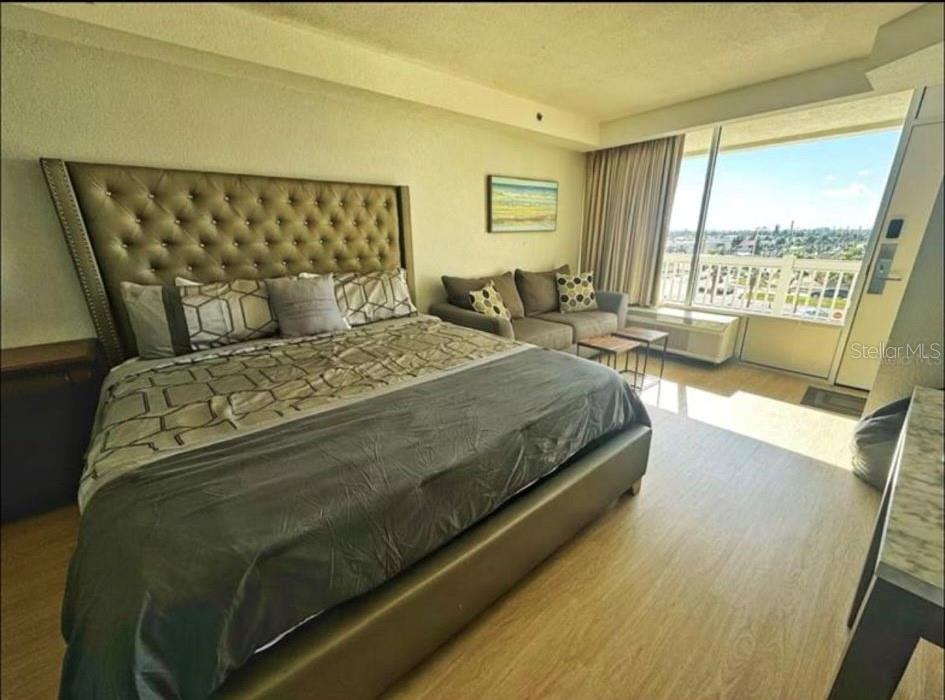 2700 North Atlantic Avenue, Unit 429 Daytona Beach, FL 32118 - Photo 7 of 11 a bedroom with a bed and wooden floor