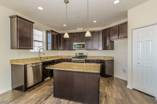 a kitchen with stainless steel appliances granite countertop a sink stove and refrigerator