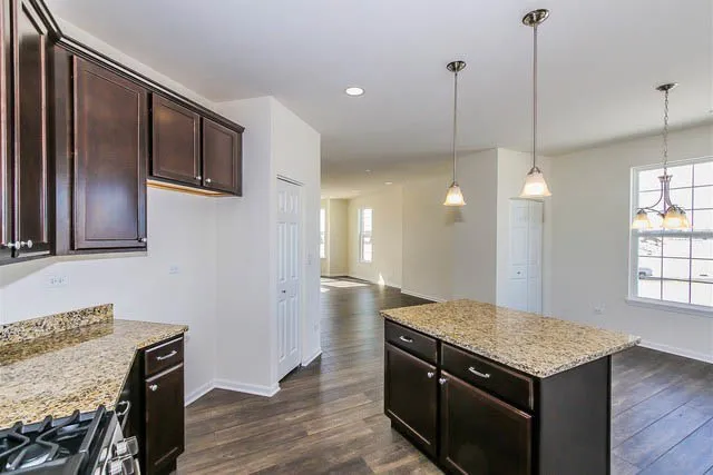 a kitchen with a stove kitchen island and wooden floor