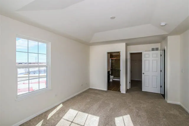 an empty room with closet and windows