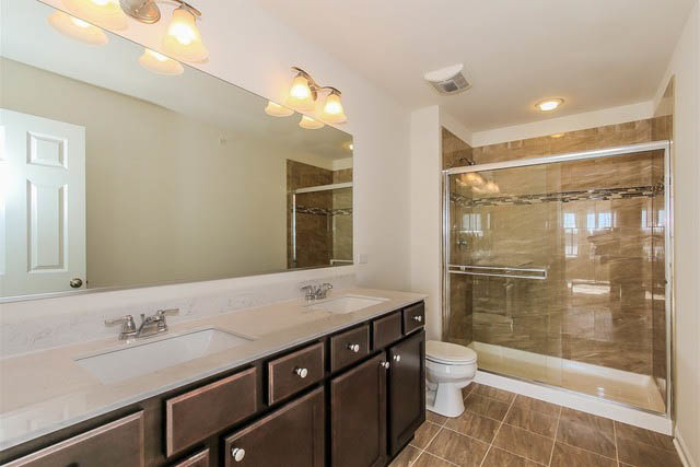 2949 Madison Drive Naperville, IL 60564 - Photo 19 of 29 a bathroom with a granite countertop sink a toilet a mirror and shower