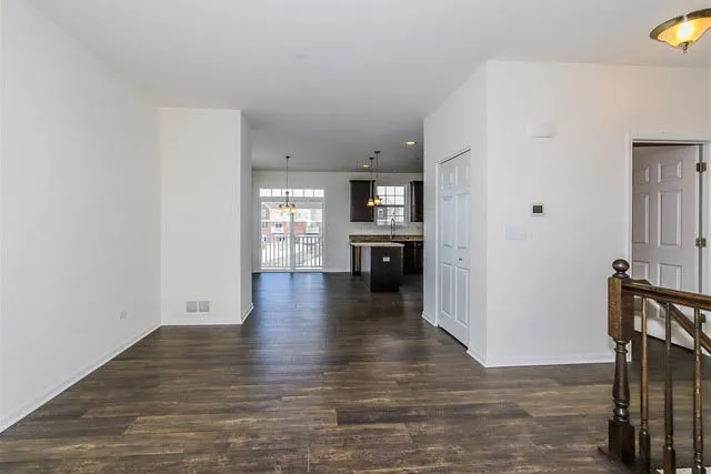 a view of a kitchen with wooden floor and a window