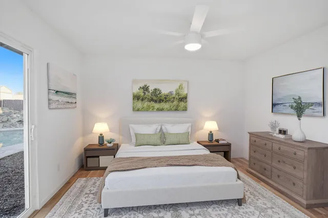 a bedroom with a bed and a lamp on dresser