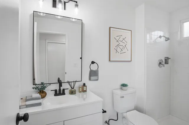a bathroom with a toilet sink and mirror