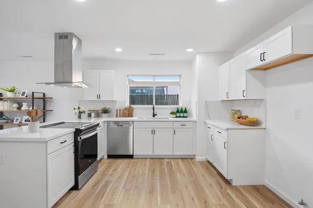 a kitchen with granite countertop white cabinets and white appliances