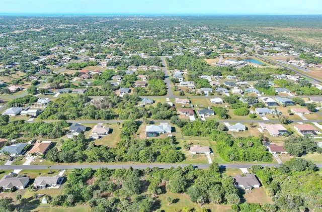 an aerial view of residential houses with outdoor space and trees