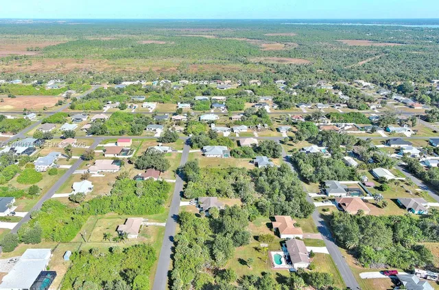 an aerial view of residential houses with outdoor space and trees