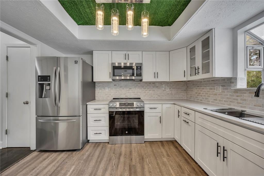 635 Anderson Walk Marietta, GA 30062 - Photo 13 of 39 a kitchen with a sink a refrigerator and a stove top oven