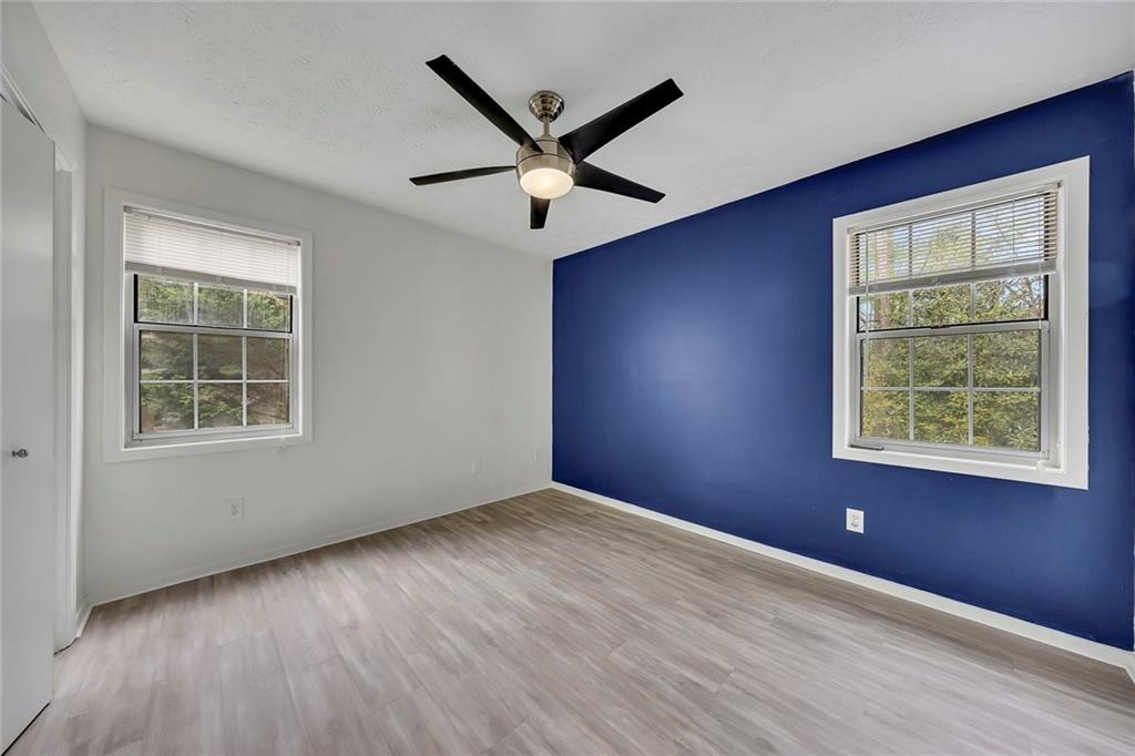 635 Anderson Walk Marietta, GA 30062 - Photo 24 of 39 an empty room with wooden floor a ceiling fan and windows