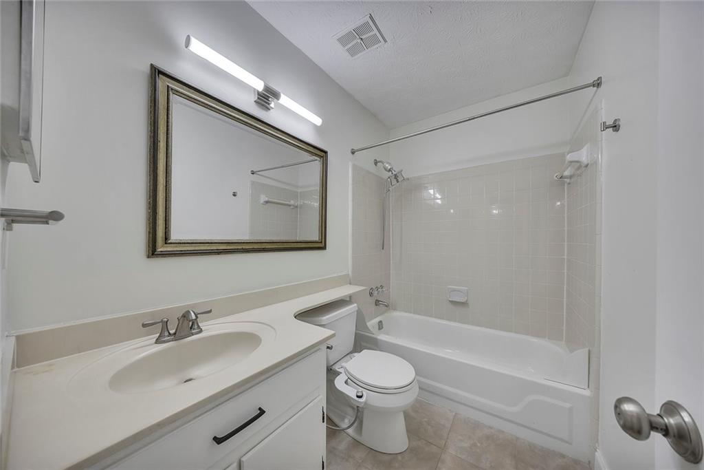 635 Anderson Walk Marietta, GA 30062 - Photo 25 of 39 a bathroom with a toilet a sink a mirror a bathtub and vanity
