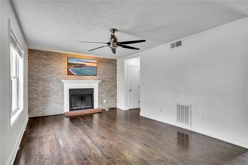 635 Anderson Walk Marietta, GA 30062 - Photo 6 of 39 an empty room with wooden floor fireplace and windows