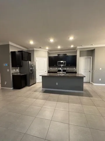 a large kitchen with kitchen island granite countertop a stove and a microwave