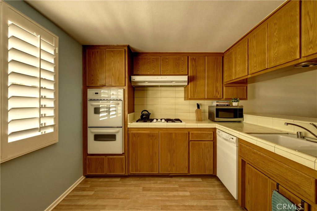 4331 West Sarah Street, Unit 10 Burbank, CA 91505 - Photo 12 of 26 a kitchen with stainless steel appliances granite countertop a sink a stove and a refrigerator