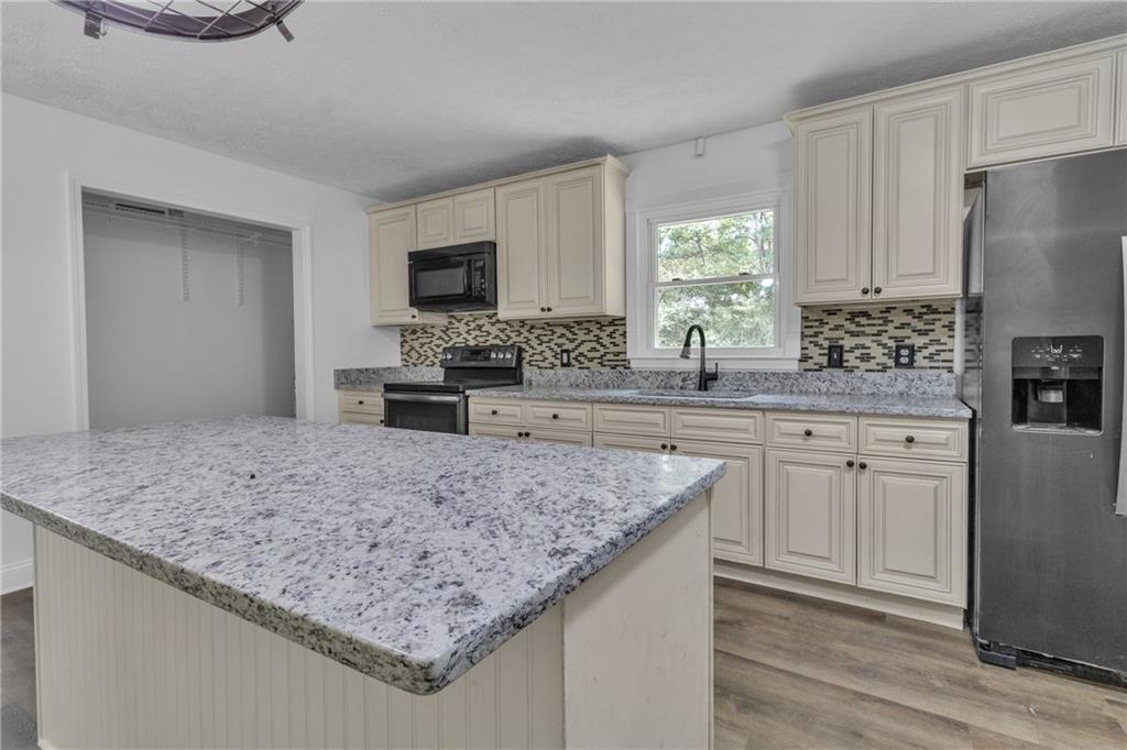 199 McKaskey Creek Road Southeast Cartersville, GA 30121 - Photo 11 of 34 a kitchen with stainless steel appliances granite countertop a sink stove and refrigerator