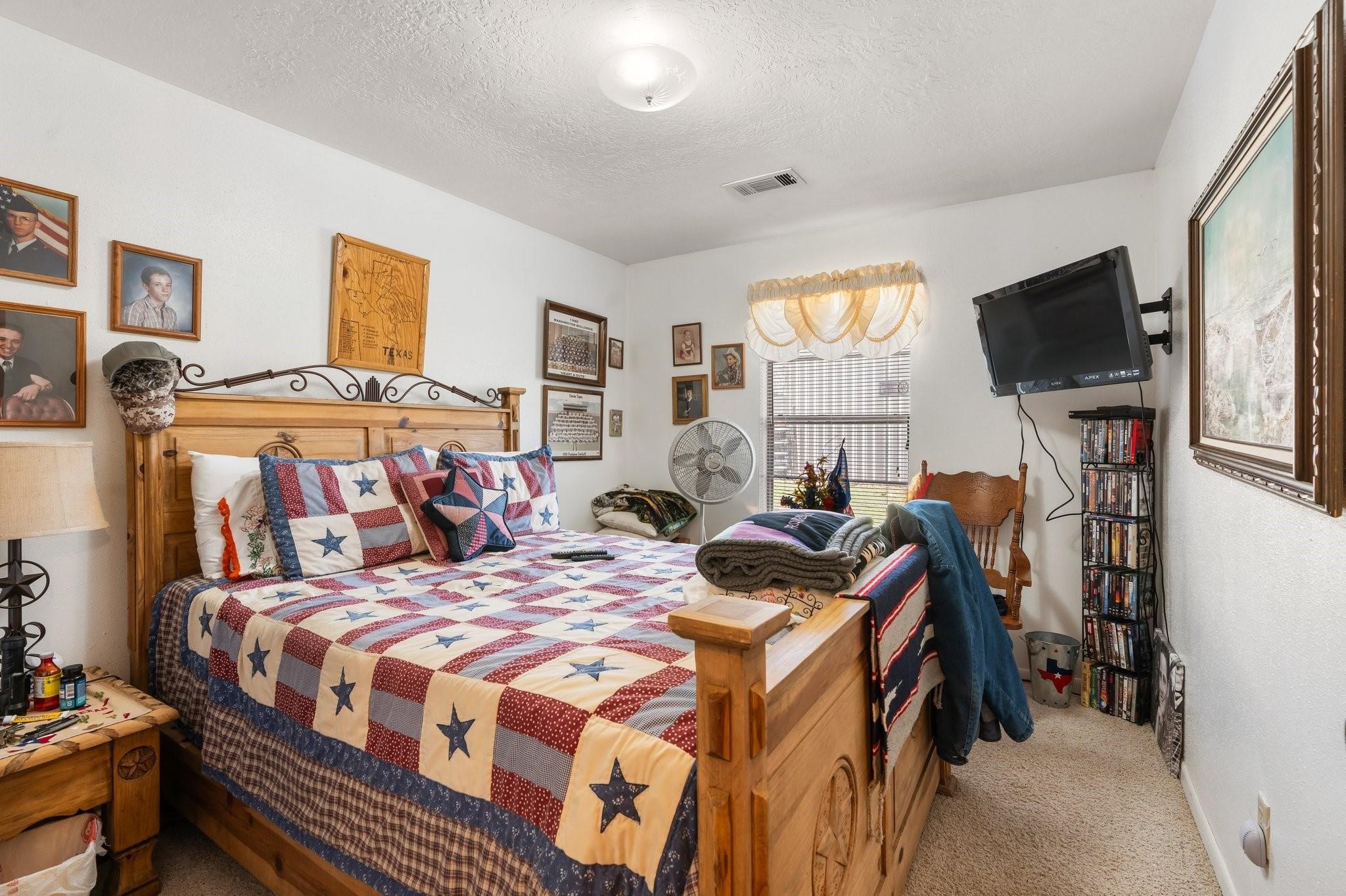 15091 Farm To Market 1485 Conroe, TX 77306 - Photo 11 of 28 a bedroom with a bed and a flat screen tv