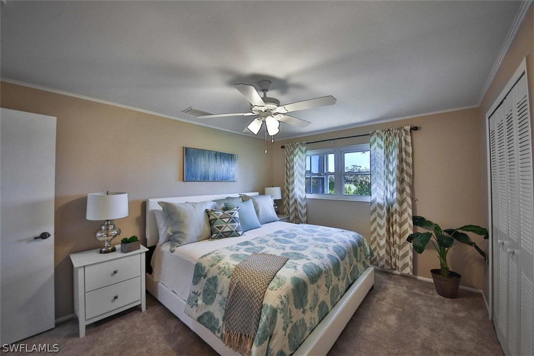 6777 Winkler Road, Unit 203 Fort Myers, FL 33919 - Photo 11 of 25 a bedroom with a bed and a chandelier