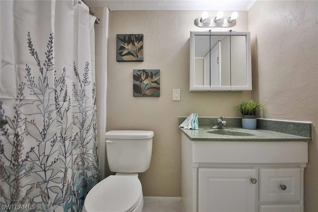 6777 Winkler Road, Unit 203 Fort Myers, FL 33919 - Photo 14 of 25 a bathroom with a granite countertop toilet sink and mirror
