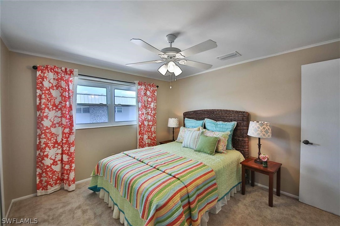 6777 Winkler Road, Unit 203 Fort Myers, FL 33919 - Photo 16 of 25 a bedroom with a bed and a chandelier