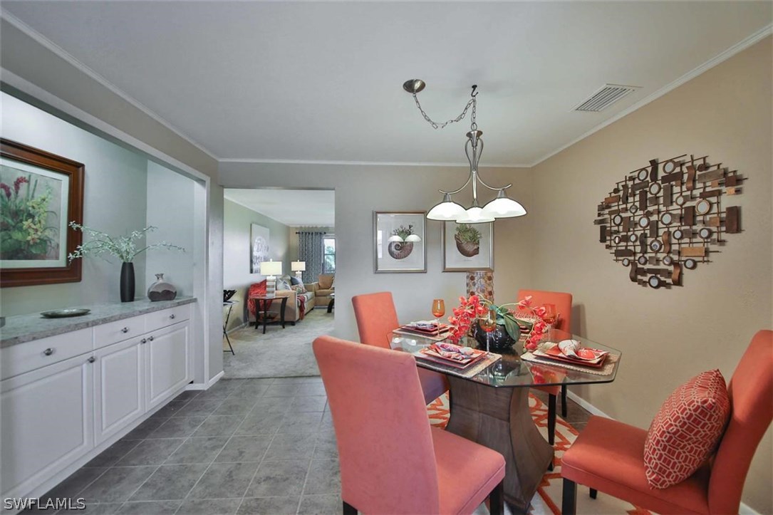 6777 Winkler Road, Unit 203 Fort Myers, FL 33919 - Photo 6 of 25 a view of a dining room with furniture and chandelier