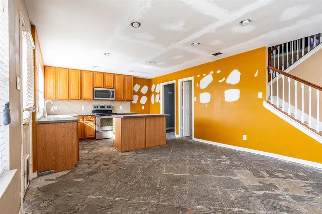 a kitchen with stainless steel appliances a refrigerator and a stove top oven