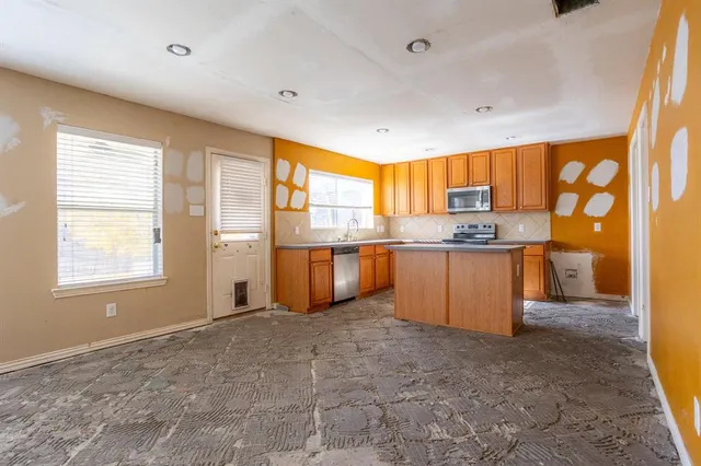 a kitchen with stainless steel appliances granite countertop a stove a sink and a refrigerator