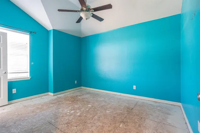 an empty room with a fan and a window