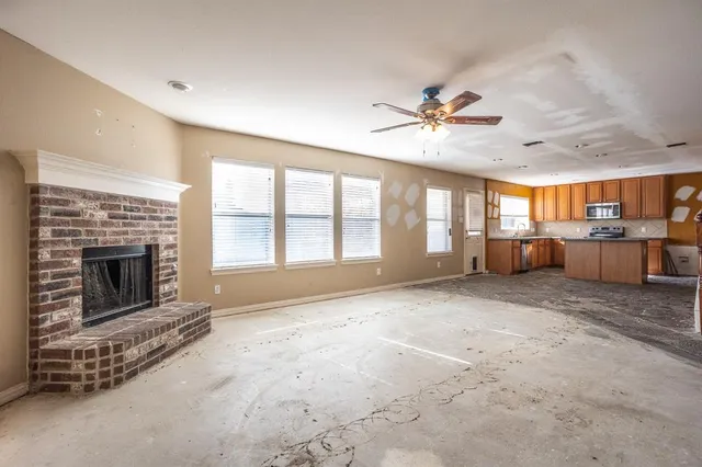 a view of an empty room with a fireplace and a window