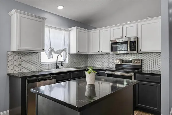 a view of a kitchen with a microwave and a ceiling fan