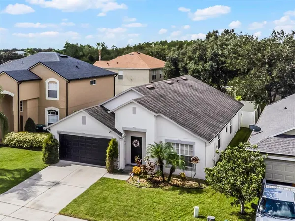 a aerial view of a house with table and chairs under an umbrella