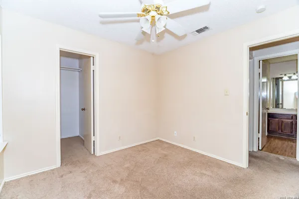 an empty room and chandelier fan in a room