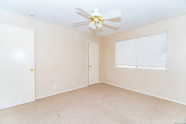 an empty room with a window and a fan