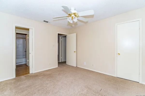 a view of an empty room with a ceiling fan