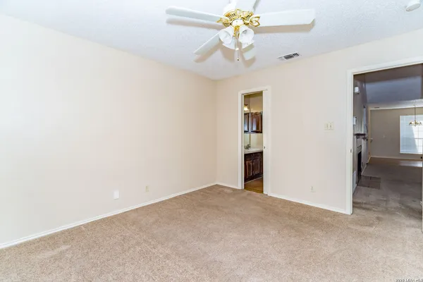 an empty room with a chandelier fan