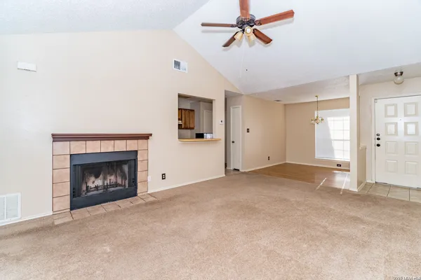a view of empty room with fireplace and fan