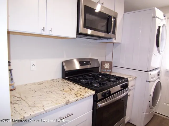 a kitchen with stainless steel appliances granite countertop a stove microwave and sink