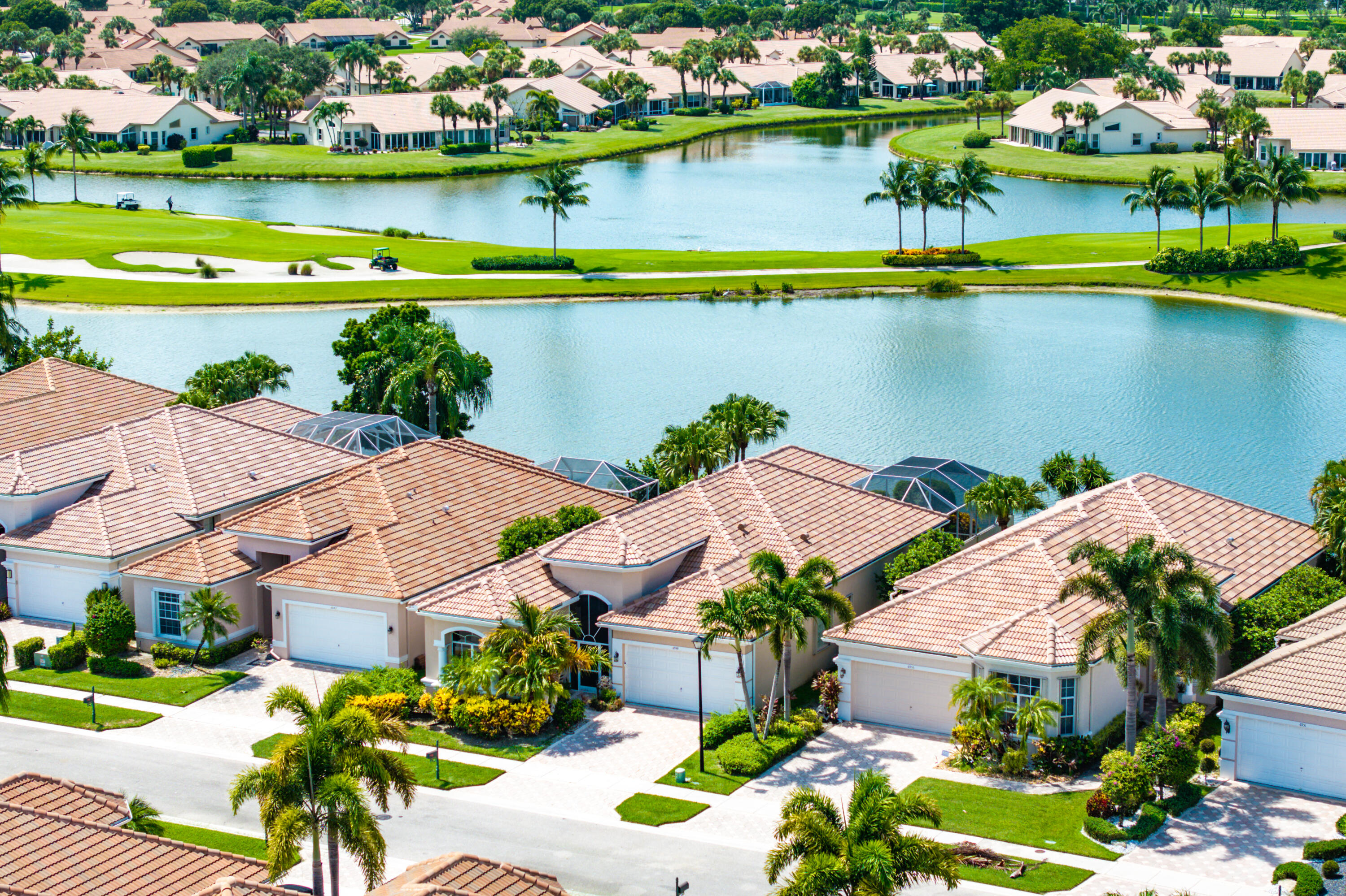 an aerial view of residential houses with outdoor space and lake view