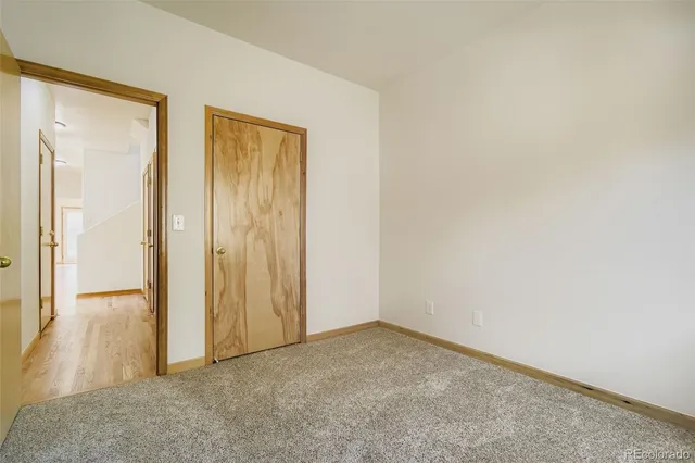 an empty room with wooden door and glass door